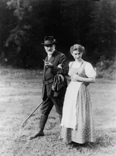 A woman in traditional Austrian dress walks with her bearded father.