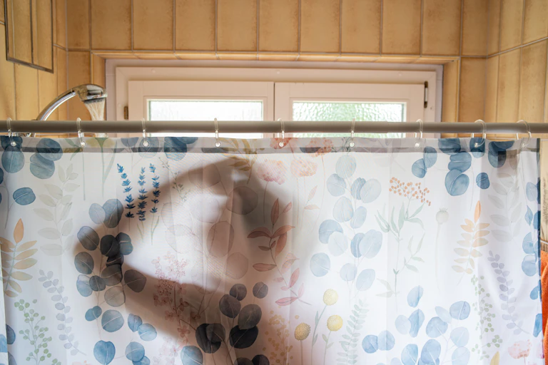 silhouette of person behind shower curtain