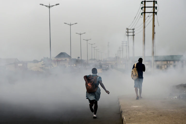 Girl walking down road filled with smoke