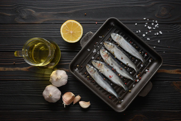 A combination of raw sardines, garlic, lemon and a bottle of oil.