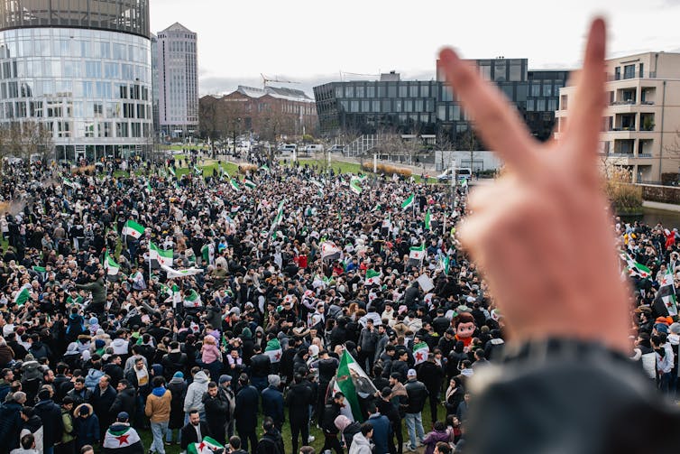 A huge crowd of people in a city plaza, celebrating.
