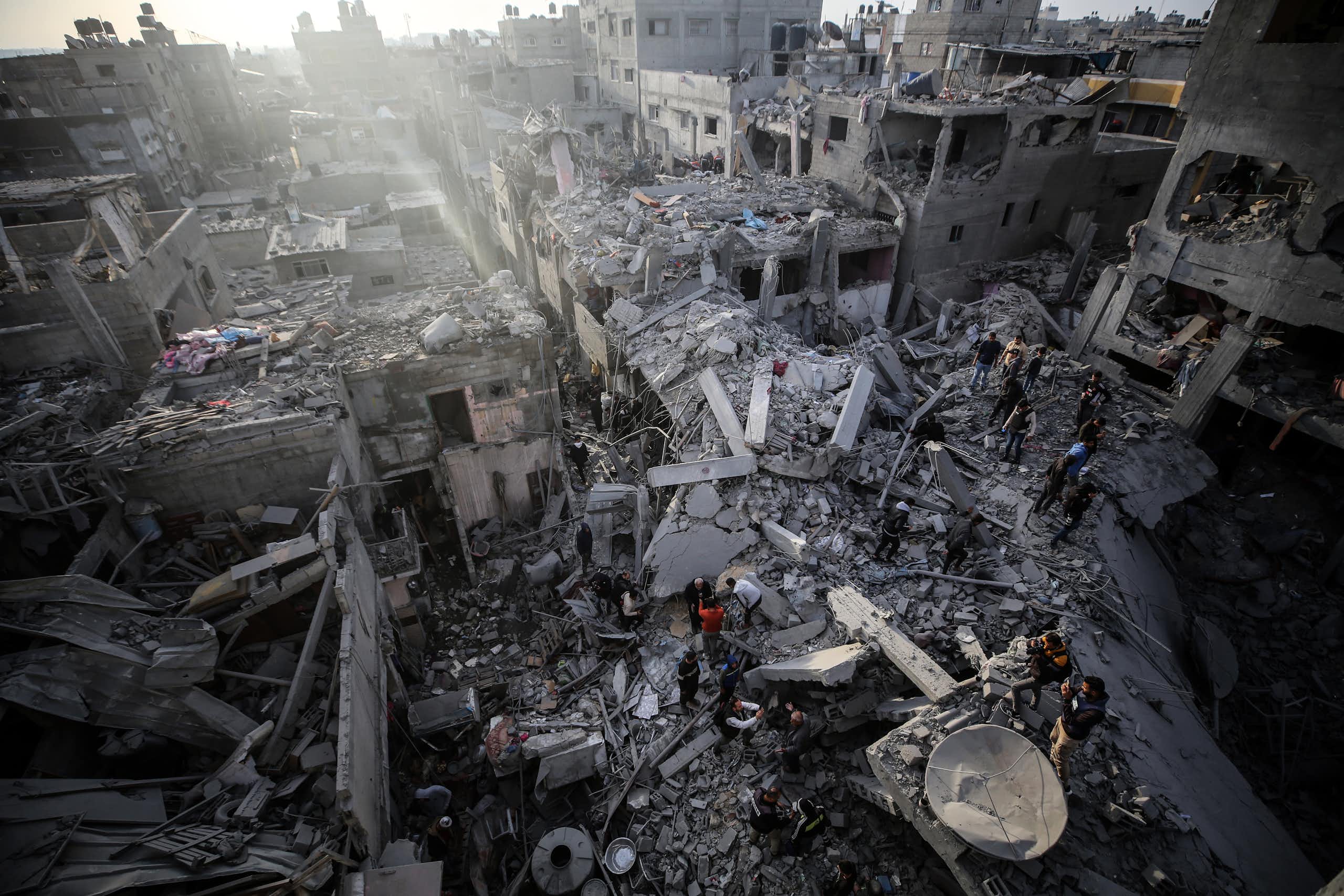 People walk through war debris.