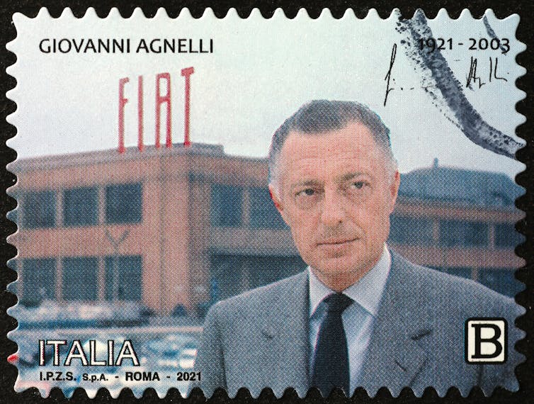 Giovanni Agnelli posing in front of a Fiat factory in Italy