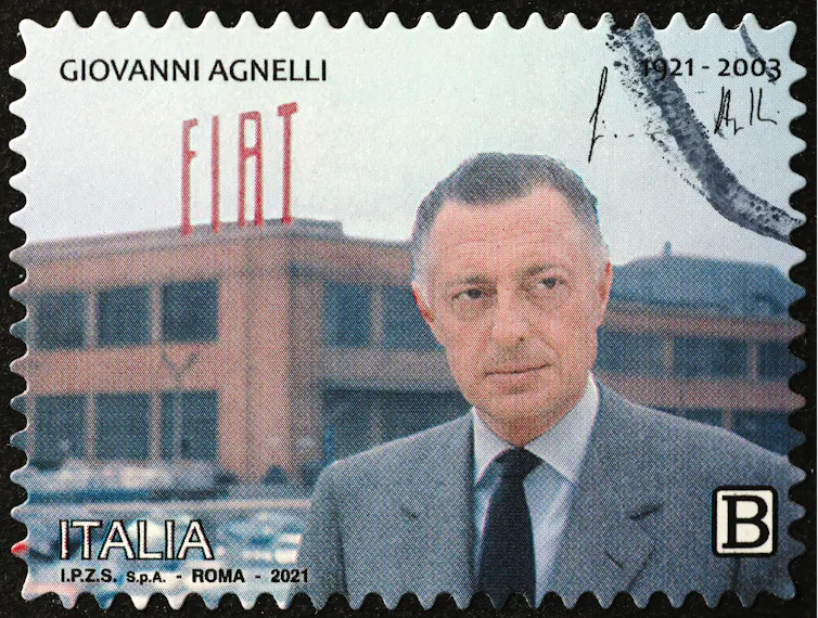 Giovanni Agnelli posing in front of a Fiat factory in Italy