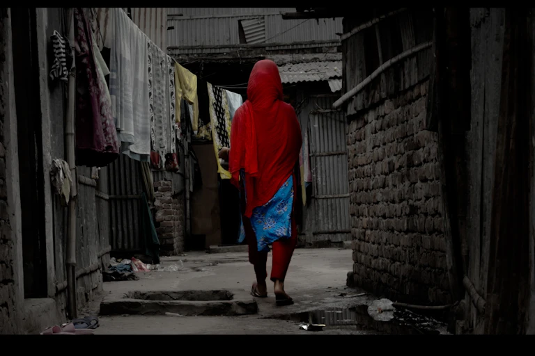 A woman dressed in red walking through a market.