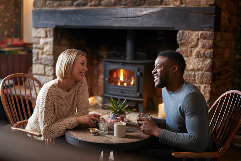 Couple Sitting At Table Drinking Tea In Traditional English Holiday Hotel