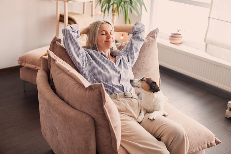 Woman relaxing on a couch with dog on her lap