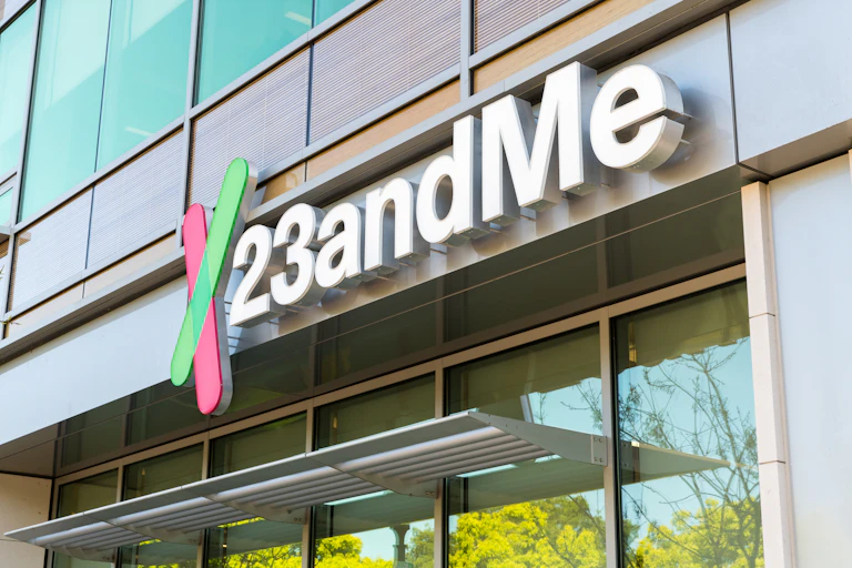 A sign that says 23andMe seen on the outside of a glass-fronted building