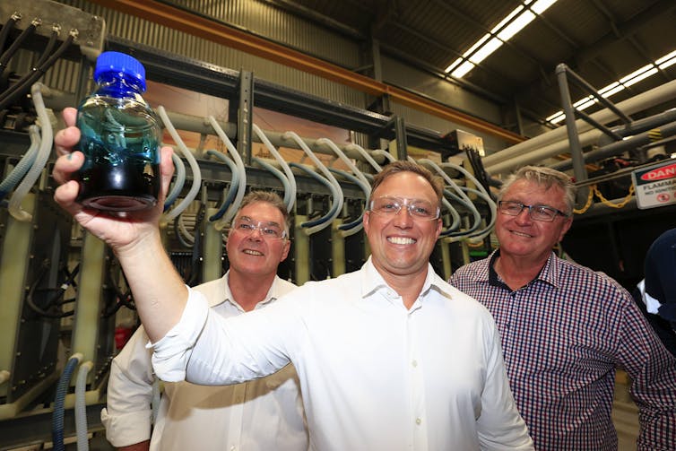 man holding bottle of battery electrolyte