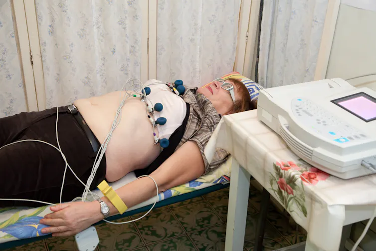 Woman in hospital cubical, having an ECG