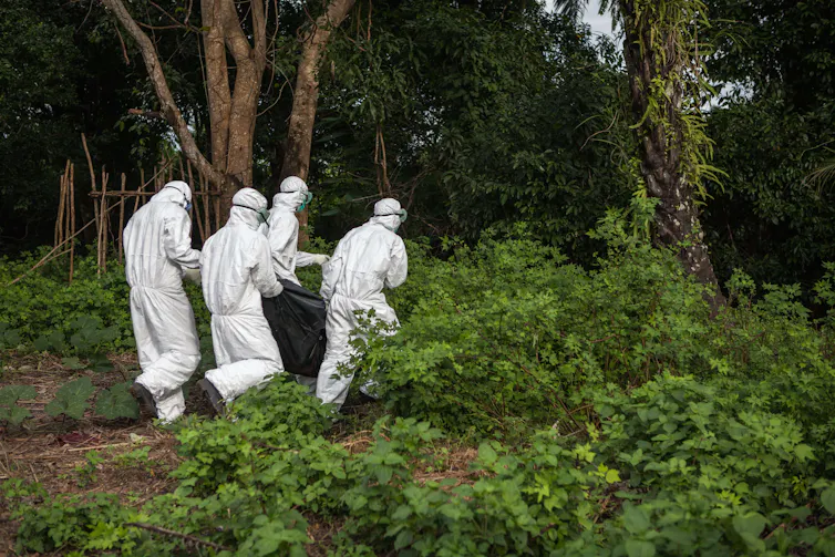 Men in protective suits carrying body