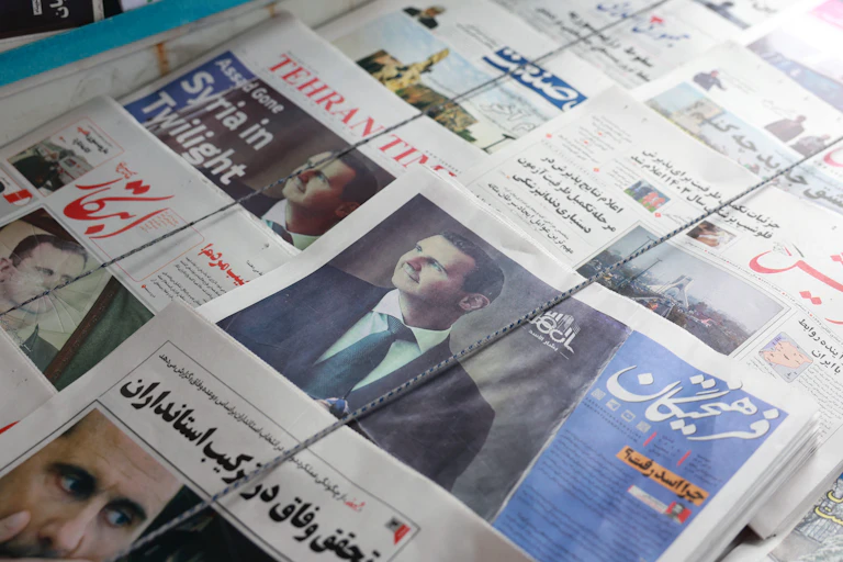 DIsplay of Iranian newspapers covering the fall of the Assad regime in Syria.