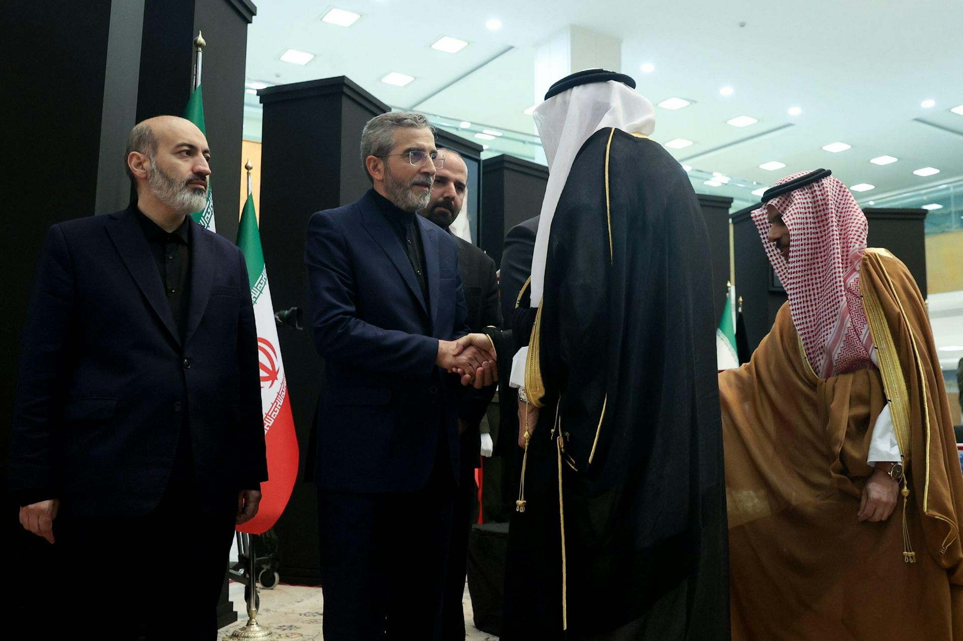Saudi foreign minister Prince Faisal bin Farhan shakes hands with acting Iranian foreign minister Ali Bagheri.