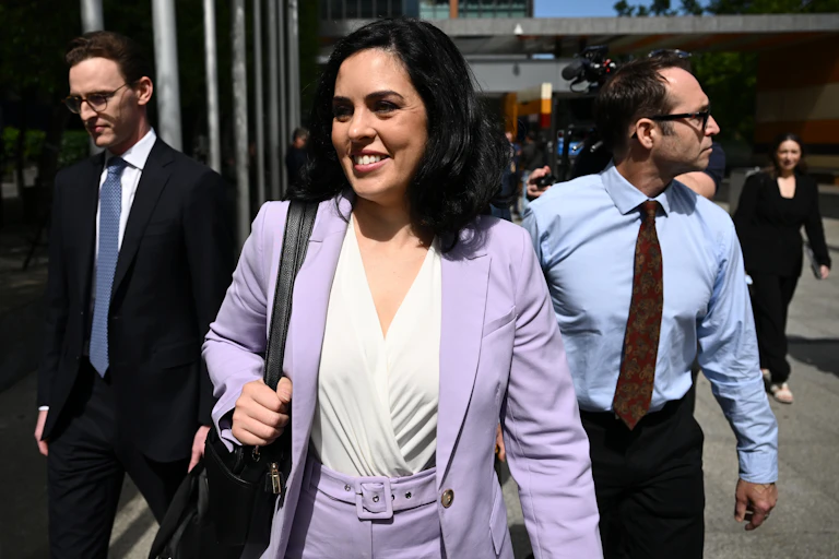 A woman in a purple suit smiles