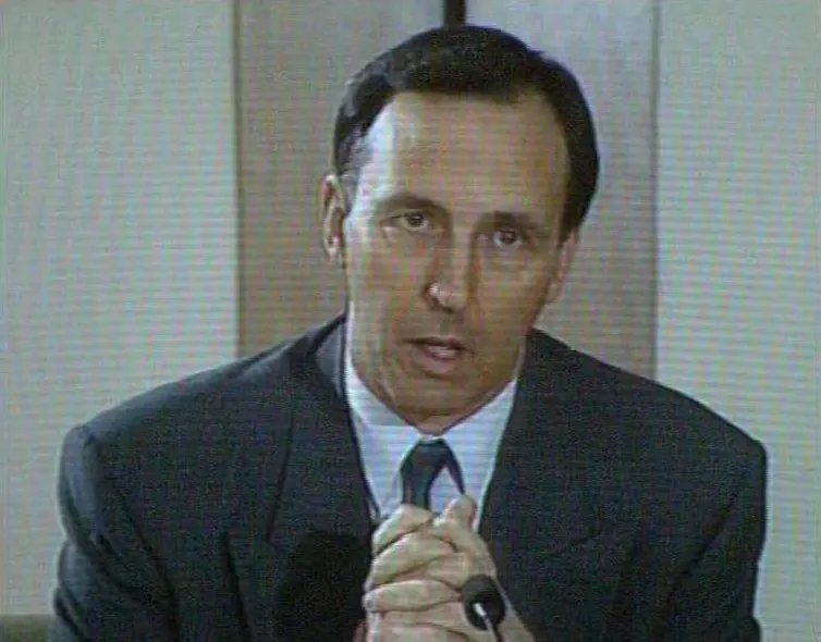 A man in a suit on television in the 90s.