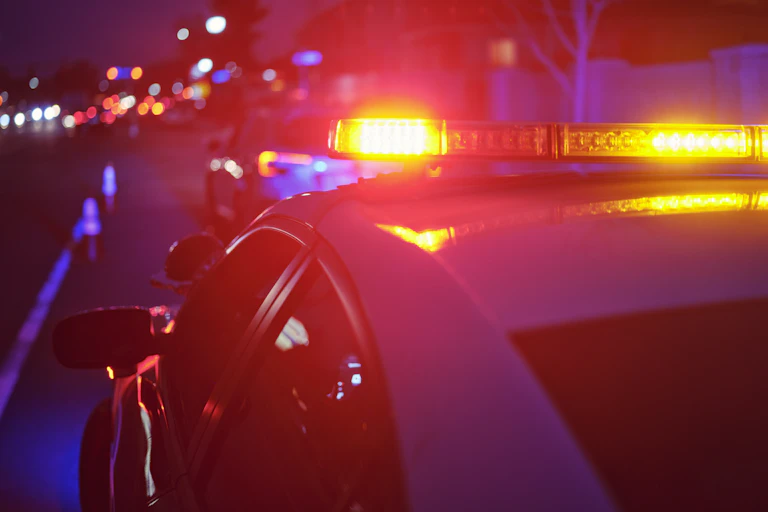View of police cruiser's flashing lights in evening