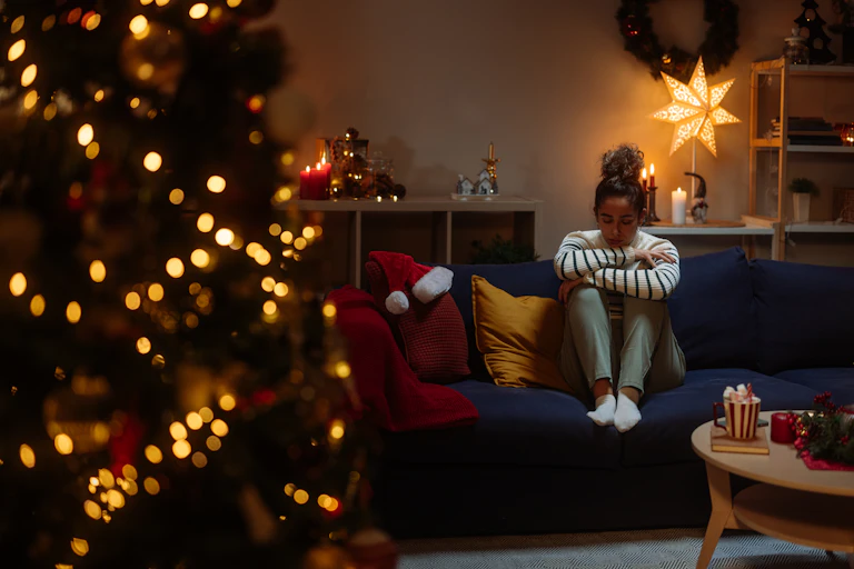 Girl cries alone next to Christmas tree