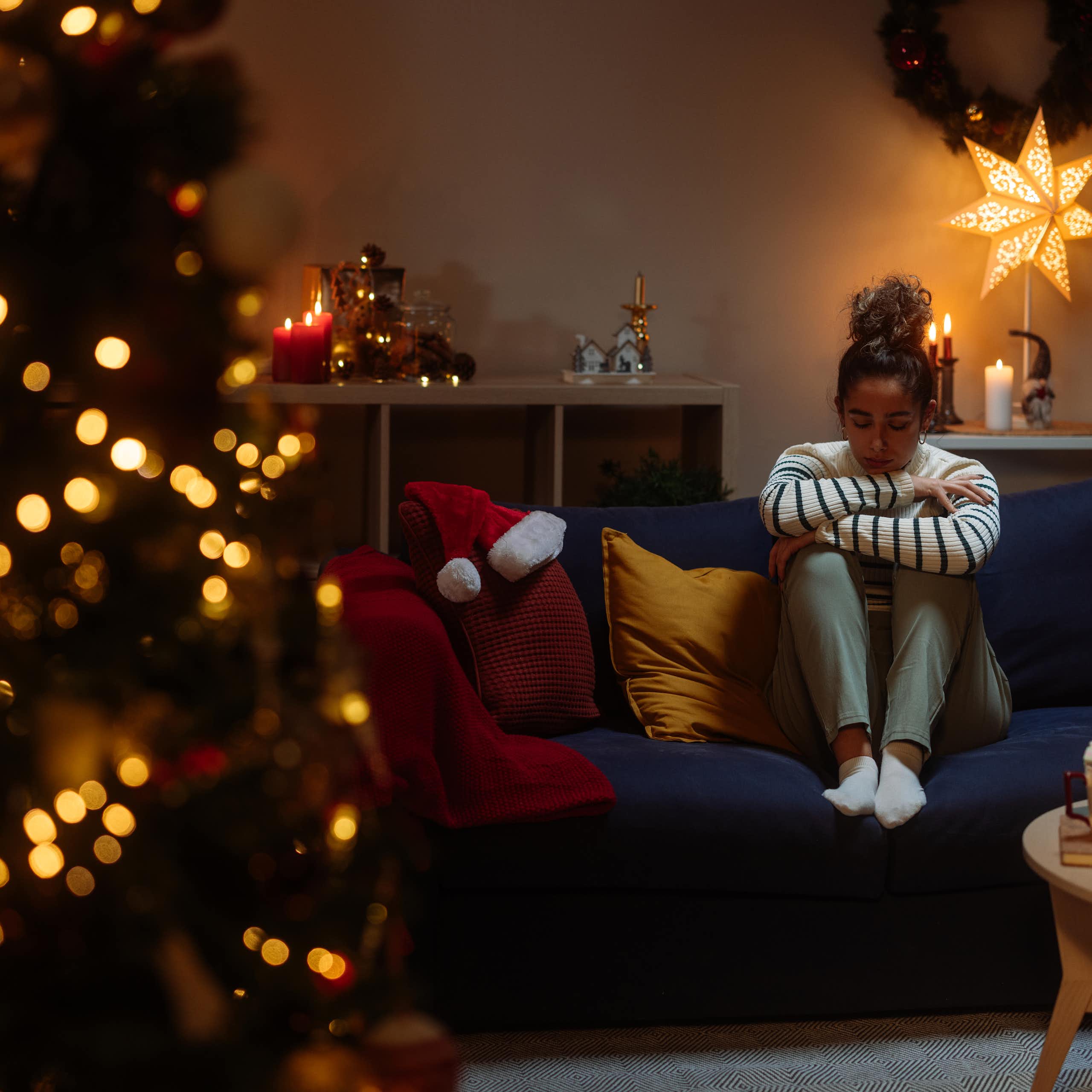 Girl cries alone next to Christmas tree