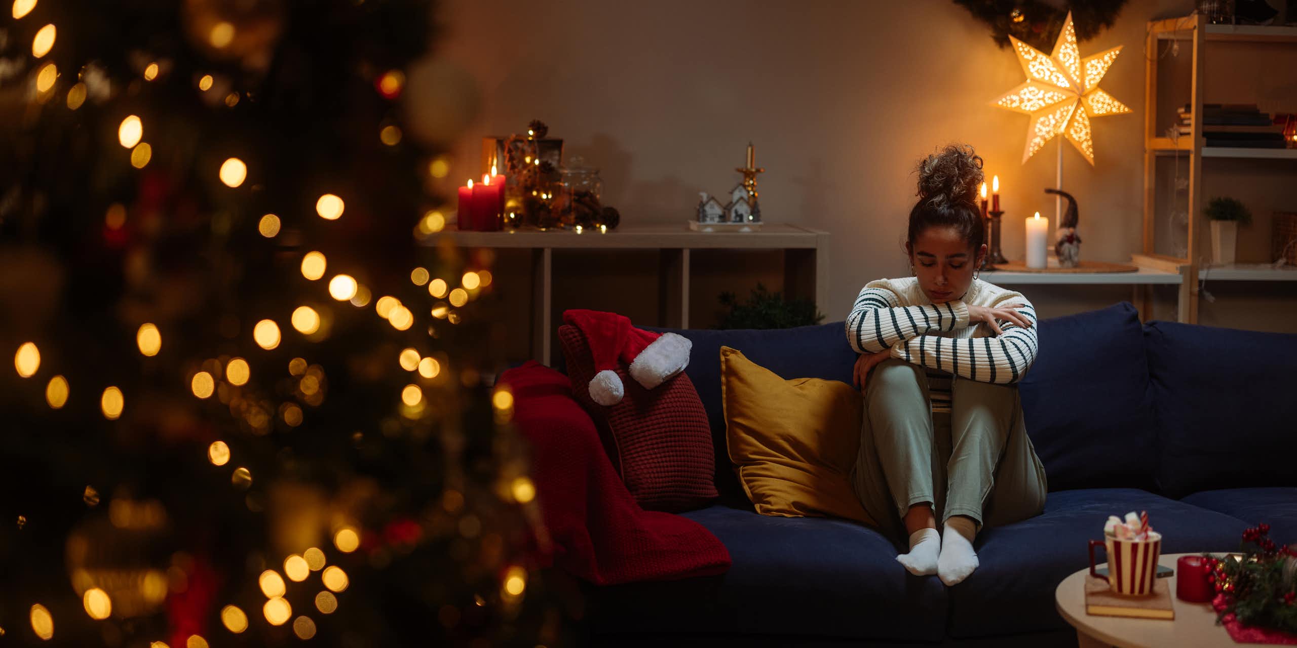 Girl cries alone next to Christmas tree