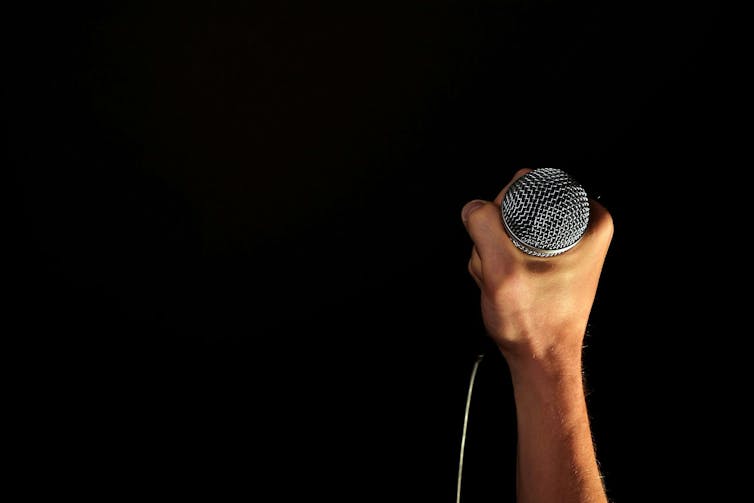 A hand holding a microphone.