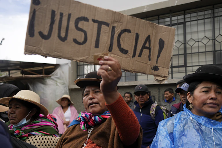 A woman at a demonstration holds a placard with the word :justicia