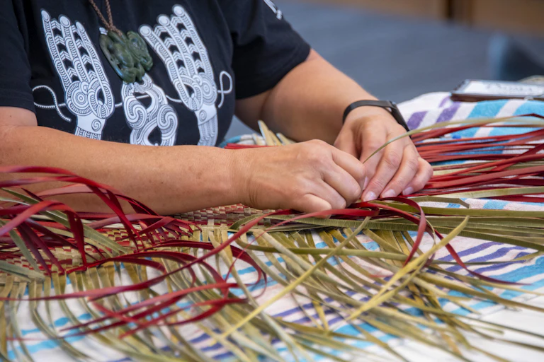 Maori woman weaving flax, focus on hands