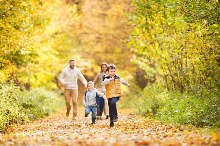 A family enjoy a walk outdoors in a forest.