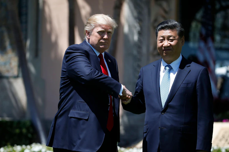 Donald Trump and Xi Jingping shake hands.