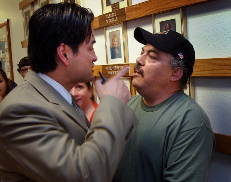 One man waves his finger in the face of another