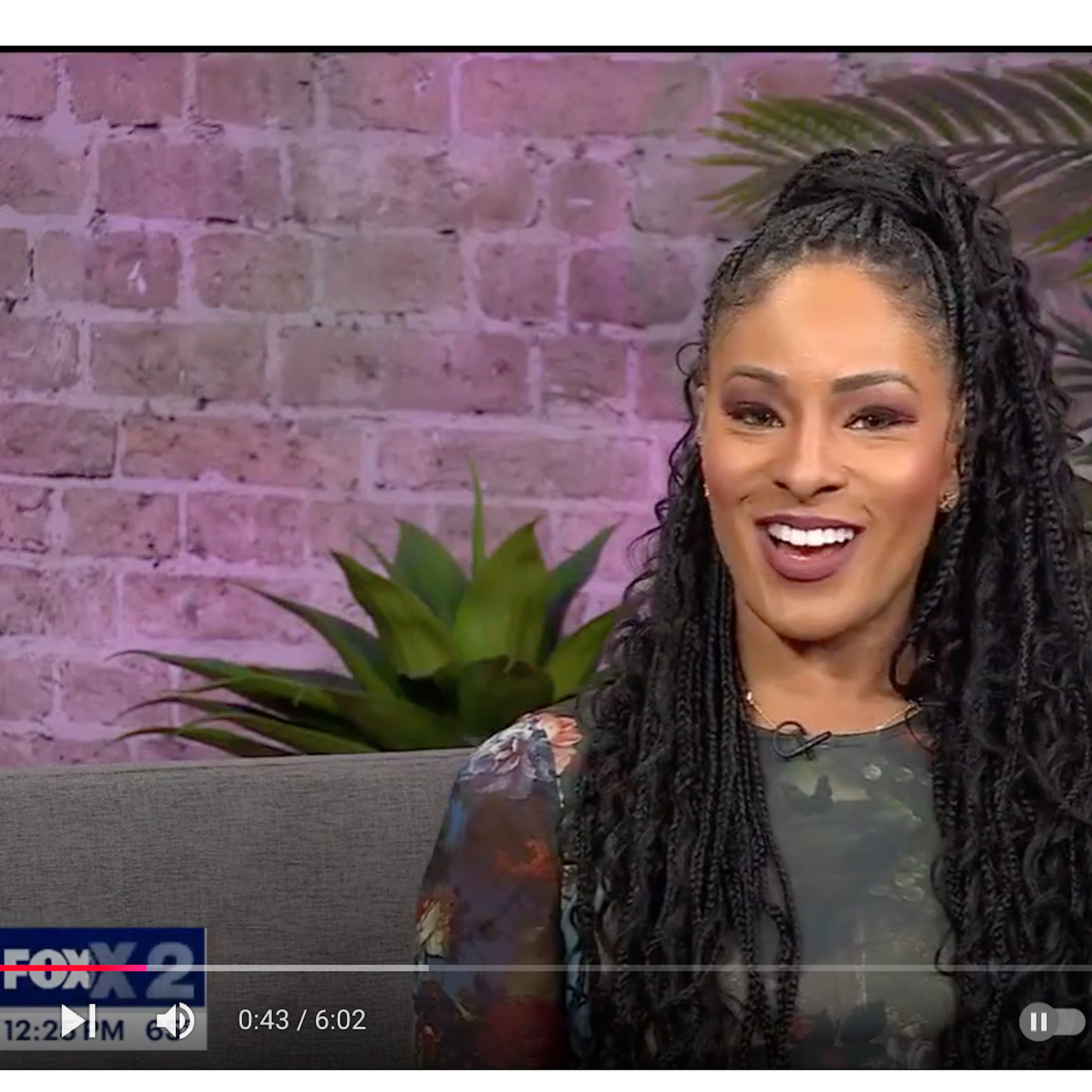 A pretty young Black woman smiles at viewers.
