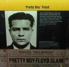 A museum display featuring a photo of a dark-haired man and newspaper headline about his slaying.