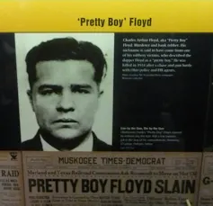 A museum display featuring a photo of a dark-haired man and newspaper headline about his slaying.