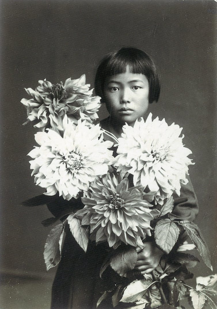 A young girl holds flowers.