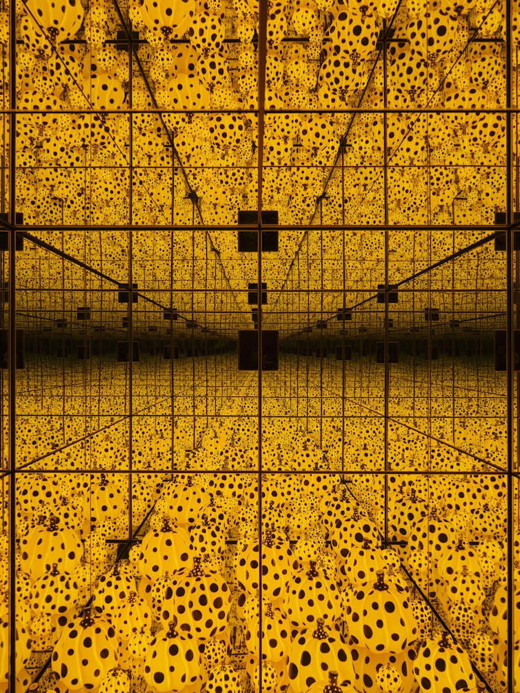 Mirrors create an infinity of yellow pumpkins with black polka dots.