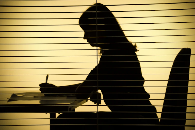 silhouette of woman signing papers