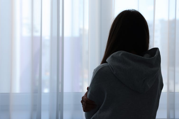 Silhouette of woman looking out a window