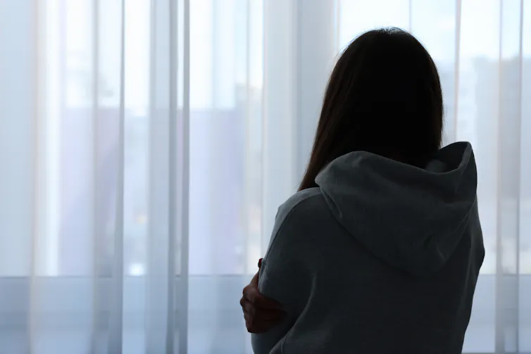 Silhouette of woman looking out a window