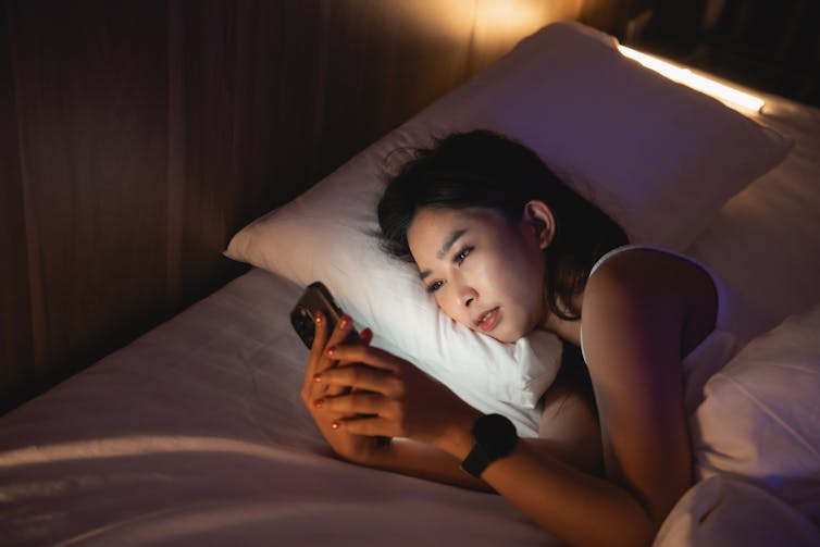 young woman using phone at night