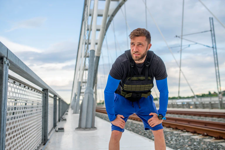 man outside exercising while wearing a black vest