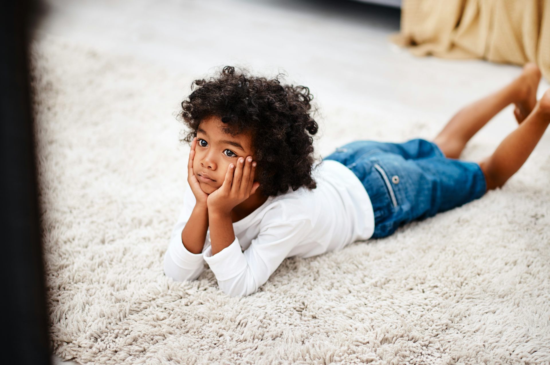 Little boy lying on floor watching TV