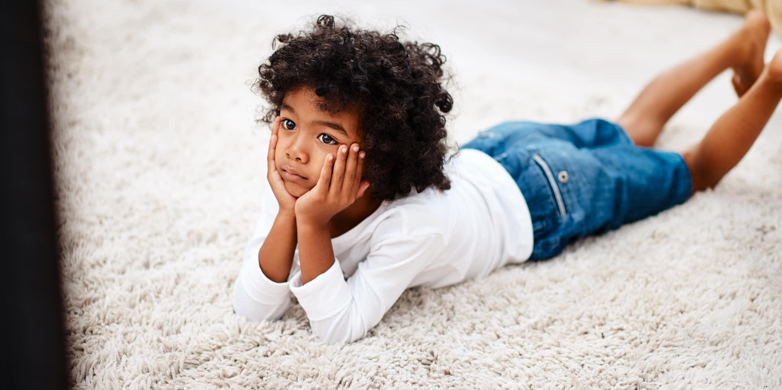 Little boy lying on floor watching TV