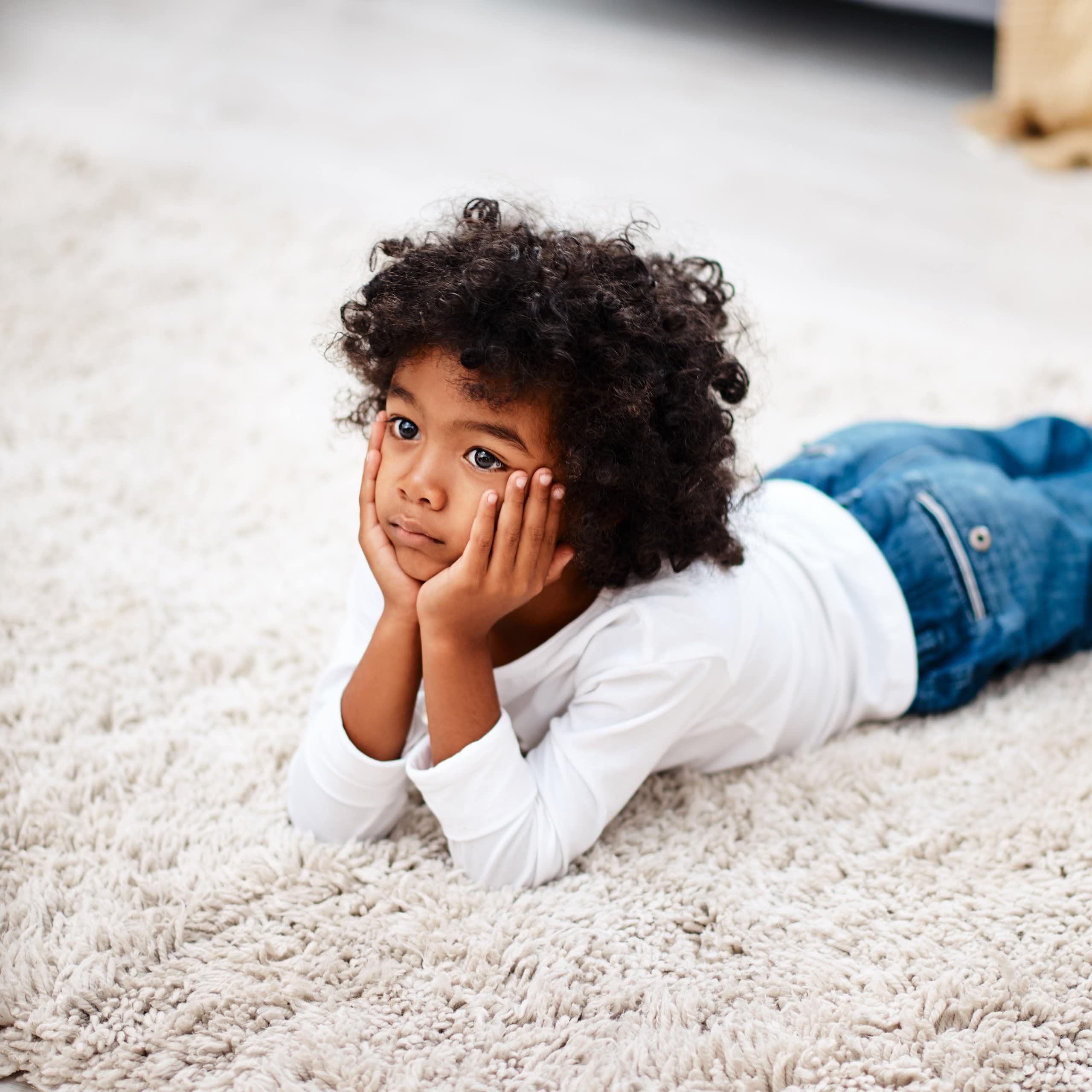 Little boy lying on floor watching TV