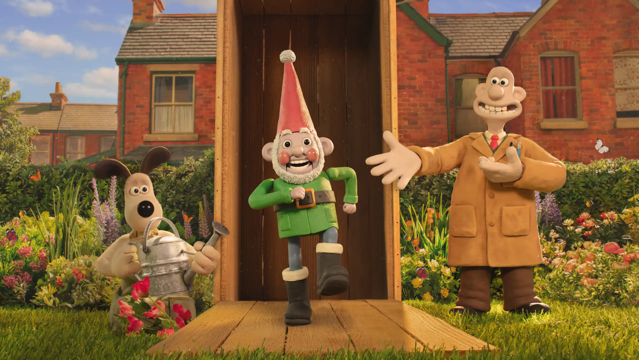 Gromit holding a watering can and Wallace presenting a garden gnome