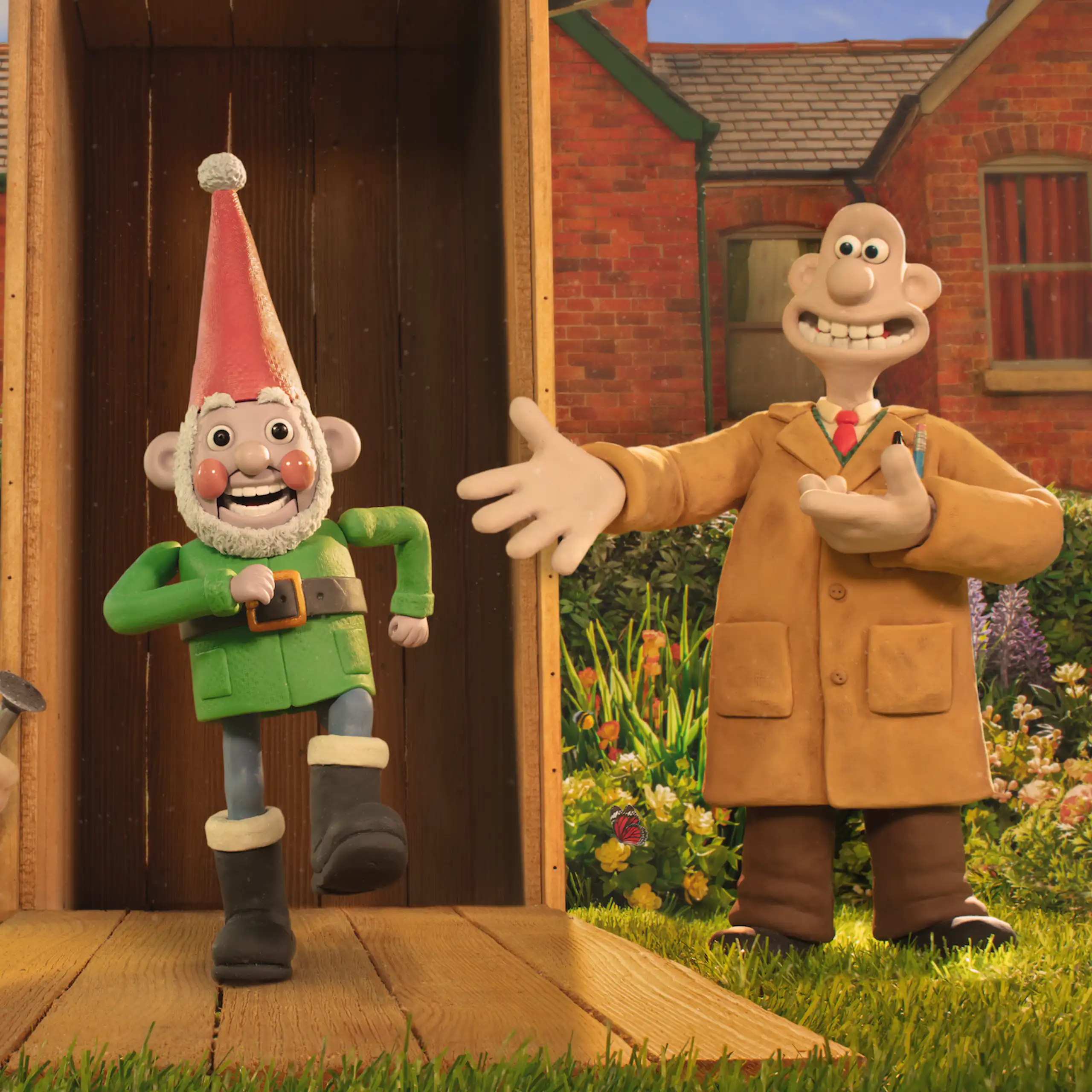 Gromit holding a watering can and Wallace presenting a garden gnome