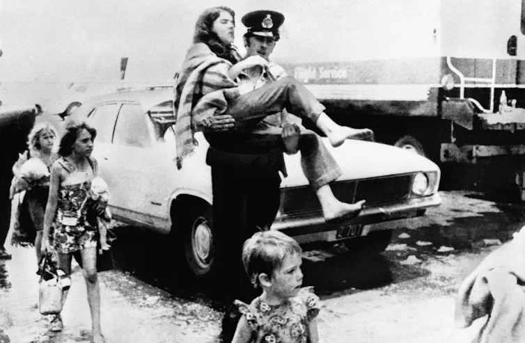 policeman carried injured girl as others walk alongside them