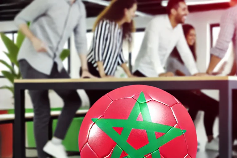 Un ballon de foot aux couleurs du Maroc avec des salariés discutant dans le fond