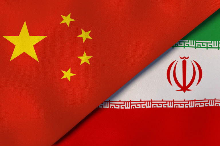 Two flags, one red with gold stars and another green, white and red, next to one another.