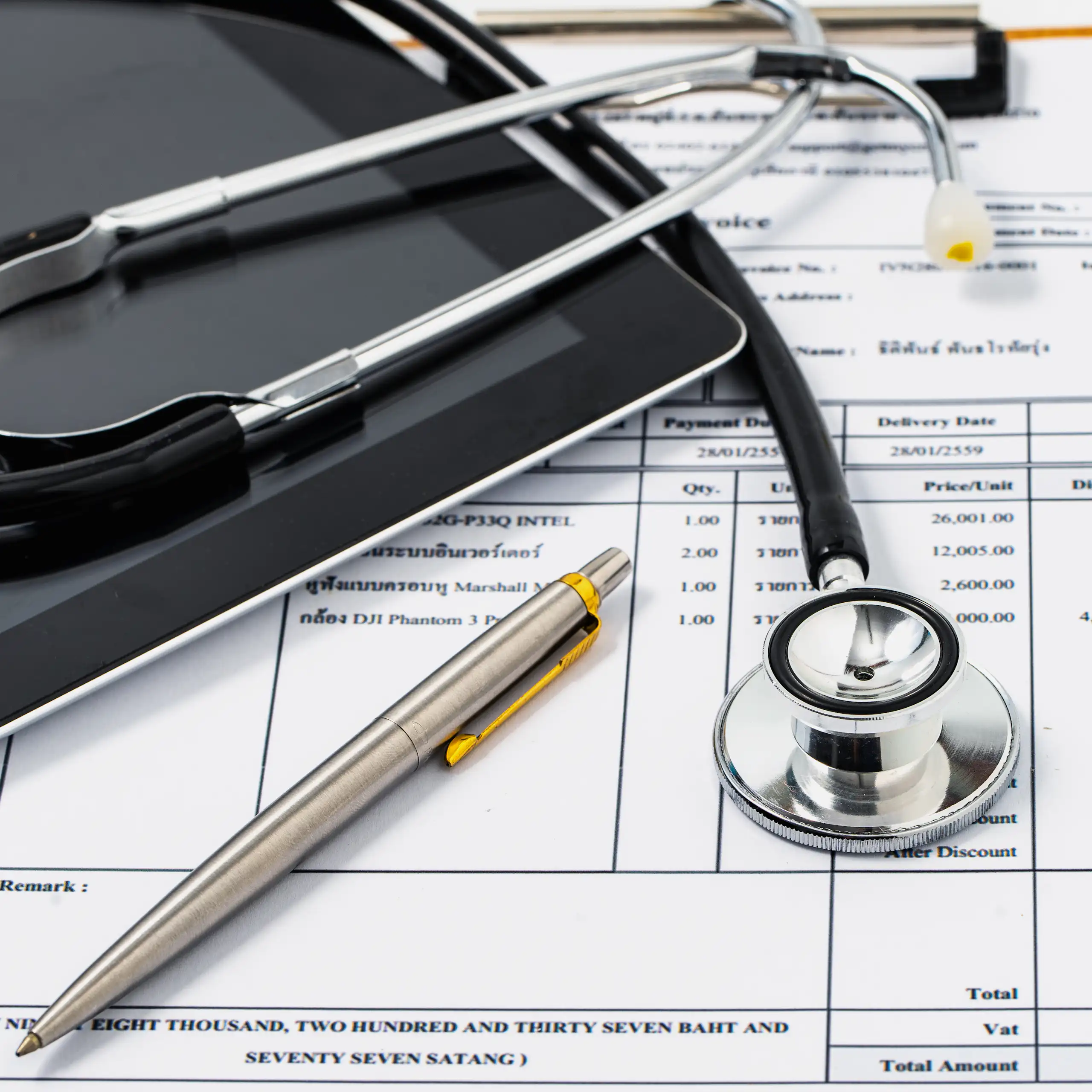Stethoscope lying on top of excessively high medical bill.