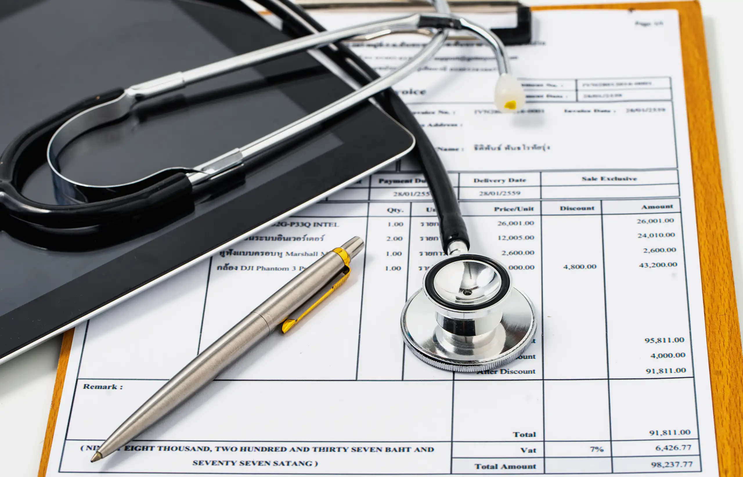 Stethoscope lying on top of excessively high medical bill.