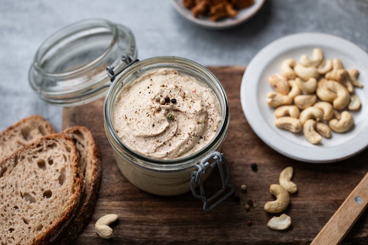 A cheese board with soem bread and a cheese made from cashews